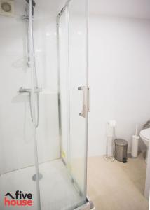 um chuveiro com uma porta de vidro na casa de banho em Five House 14B no Porto