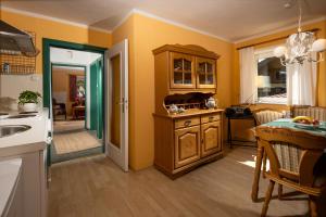 cocina con paredes amarillas, mesa y fregadero en Villa Aldefeld, en Berchtesgaden