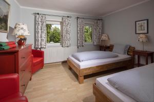 ベルヒテスガーデンにあるVilla Aldefeldのベッドルーム1室(ベッド1台、赤い椅子付)