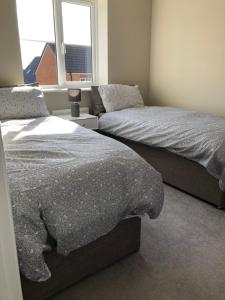 a bedroom with two beds and a window at Hill House - 5 Mins Merry Hill - Perfect for Contractors & Families in Brettell Lane