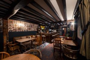 un ristorante con tavoli e sedie in legno e un bar di George and Dragon a Hurstbourne Tarrant