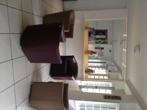 a room with some brown chairs and a mirror at Pousada do Forte Recife in Recife