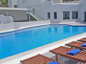 a large swimming pool with two chairs and a swimming pool at Smy Bellevue Mykonos in Tourlos
