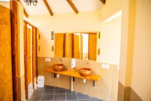 a bathroom with two copper sinks and a mirror at Colibrí Eco Lodge & Camping in La Paz