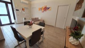 eine Küche und ein Wohnzimmer mit einem Tisch und Stühlen in der Unterkunft B&B Sweet Home in Grumo Appula