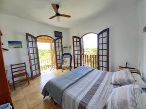 a bedroom with a bed and a balcony at Homestay Villa Giulia in Juquei