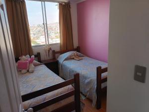 1 dormitorio con 2 camas individuales y ventana en hospedaje en departamento compartido, en Valparaíso