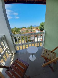 a balcony with a table and chairs and a view at Homestay Villa Giulia in Juquei