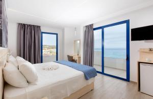 a bedroom with a bed with a view of the ocean at Raffaello Beach in Faliraki