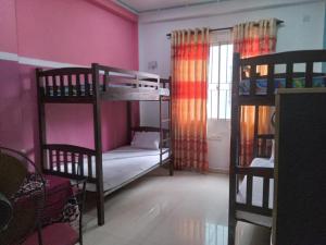 a room with two bunk beds and a window at Le Petit Hotel & Restaurant in Negombo