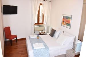 a small room with a white bed and a table at VG [VIA DEL CORSO 5 STELLE] Luxury apartment in Rome