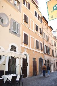 duas pessoas a andar numa rua ao lado de um edifício em VG [VIA DEL CORSO 5 STELLE] Luxury apartment em Roma
