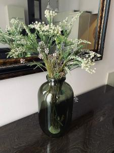 a vase filled with flowers on a table in front of a mirror at Apartment Abbazia in Opatija