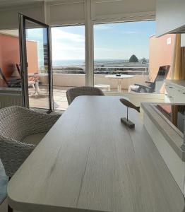 a wooden table in a room with a view of the ocean at STRANDIDYLL, 23 - Typ A1S in Grömitz