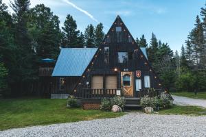 ein Haus mit einem Gameradach mit einer Eingangstür in der Unterkunft Au Sommet du Fjord in Sacré-Coeur-Saguenay