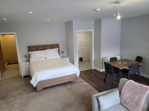 Quay St Apartment في سليغو: غرفة نوم بسرير وطاولة وكراسي