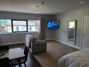 a bedroom with a bed and a tv on the wall at Quay St Apartment in Sligo