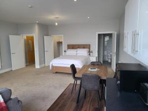 1 dormitorio con 1 cama, mesa y sillas en Quay St Apartment en Sligo