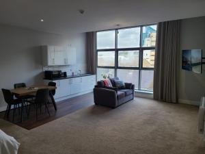Quay St Apartment في سليغو: غرفة معيشة مع أريكة وطاولة ومطبخ