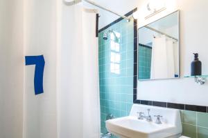 
a bathroom with a sink, mirror, and shower stall at Freehand Miami in Miami Beach
