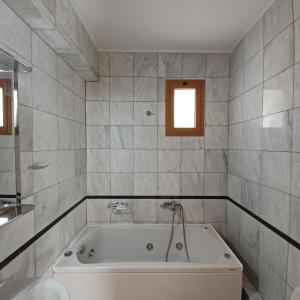 a white bath tub in a bathroom with a window at Villa Syvros in Sívros