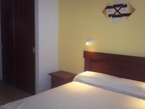 a bedroom with a bed and a light on the wall at Córdoba departamento céntrico in Cordoba