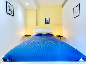 1 cama azul grande en un dormitorio con 2 lámparas en Rouen - Appartements - Centre Historique - Tout Confort - Internet Fibre en Rouen