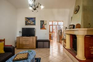uma sala de estar com lareira e televisão em Villa Salento em Cellino San Marco