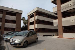 zwei Autos auf einem Parkplatz vor einem Gebäude geparkt in der Unterkunft Emma's House in Cefalú
