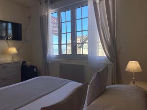 una camera con letto e finestra di Hôtel de la Plage a Houlgate