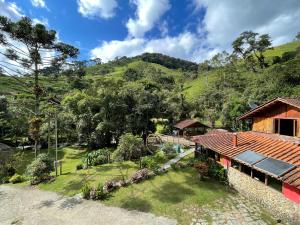 eine Luftansicht eines Hauses mit Garten in der Unterkunft Chalé rústico truta dá floresta 3 in Visconde De Maua