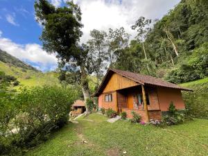 ein kleines Haus inmitten eines Feldes in der Unterkunft Chalé Truta da Floresta in Visconde De Maua