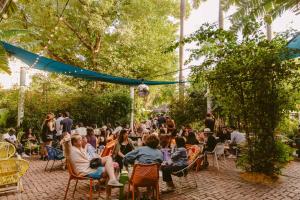 a crowd of people sitting in chairs in a garden at Freehand Miami in Miami Beach