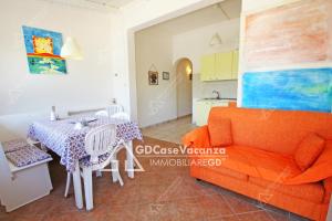 a living room with an orange couch and a table at GD Case Vacanza - Ville del Rio in Fontanelle