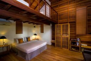 
a bedroom with a bed and a wooden floor at Palm Paradise Cabanas & Villas Beach Resort in Tangalle

