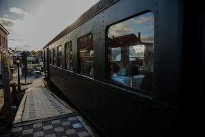 a black train with a window on a platform at Gasthof De Statie in Wilderen