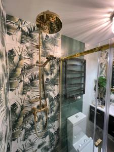 a bathroom with a shower with a green and white wallpaper at Comfort Zone Ostróda Villa Apartment B in Ostróda +49 photos