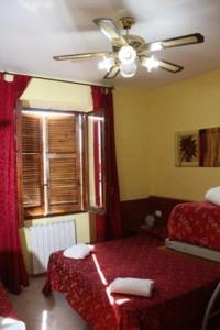 a bedroom with a red bed and a ceiling fan at Viennese Due in Rome