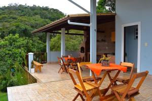 un patio avec des tables et des chaises sur un patio dans l'établissement Casa Espetacular no Centro da Serra, à Nova Friburgo