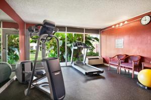 Ramada by Wyndham Sunnyvale/Silicon Valley في سانيفيل: غرفة مع صالة ألعاب رياضية مع آلة ركض وكراسي