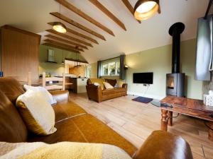 een woonkamer met een bank en een open haard bij Forest Farm Cottage in Haywards Heath