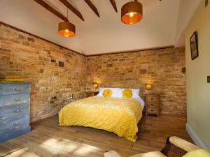 une chambre avec un lit et un mur de briques dans l'établissement Forest Farm Cottage, à Haywards Heath