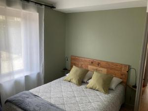 a bedroom with a bed with two pillows and a window at L'Atelier 1 in Corcelles-les-Arts