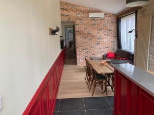 a room with a table and chairs and a brick wall at L'Atelier 1 in Corcelles-les-Arts +12 photos