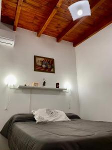 a bedroom with a bed and a shelf on the wall at Like Home in Salta