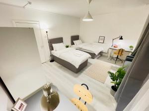 um quarto com duas camas e uma mesa num quarto em Leytonstone House - SleepyLodge em Londres