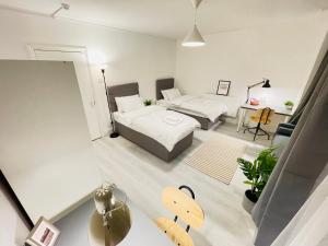 a bedroom with two beds and a table in a room at Leytonstone House - SleepyLodge in London