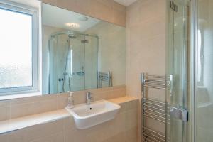a bathroom with a sink and a glass shower at Shrimper's Cottage in Wadebridge +15 photos
