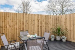 a patio with a table and chairs in front of a fence at Shrimper's Cottage in Wadebridge