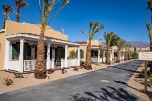 a house with palm trees in front of a street at The Ranch At Death Valley in Death Valley